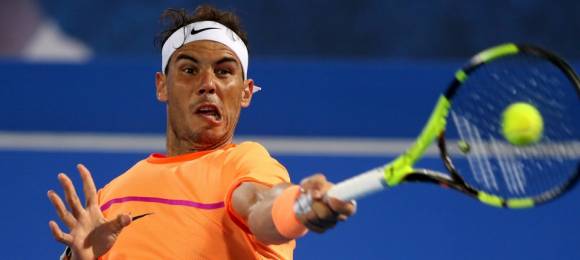 Nadal golpea una bola contra Raonic en Abu Dabi 2016